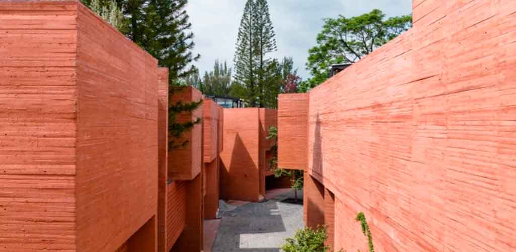 Perforaciones geométricas caracterizan bloque de viviendas de hormigón coloreado en México